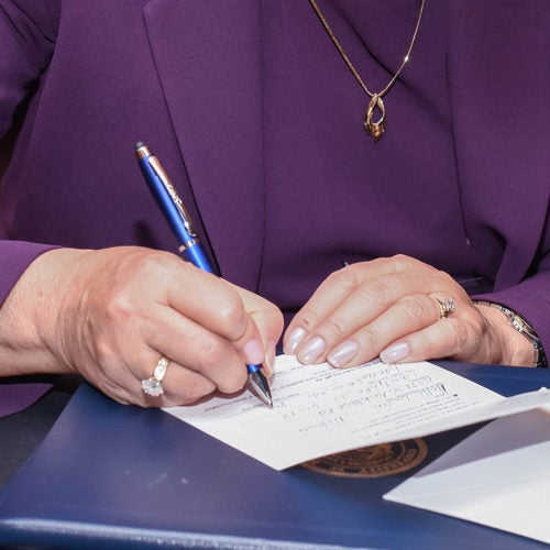 Close up on paper and pen of a person handwriting a note