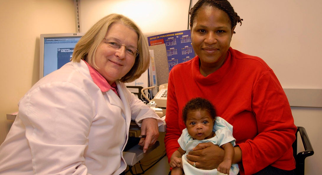 Midwife with woman patient and baby