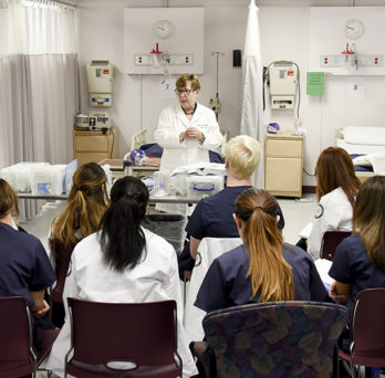 Teacher standing in front of students in clinical classroom
                  