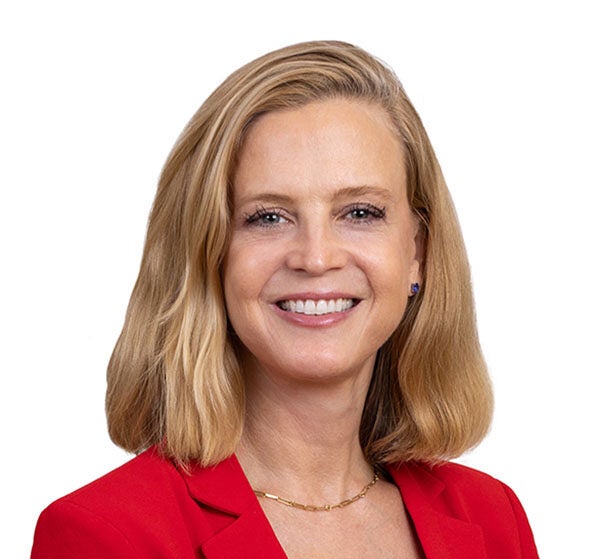 Woman in red suit jacket smiling