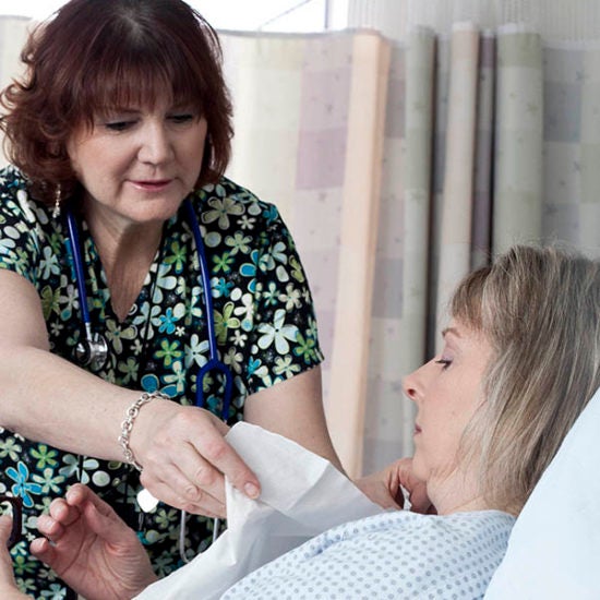 Nurse caring for patient in bed