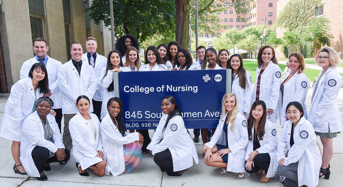 Students pose with College of Nursing sign