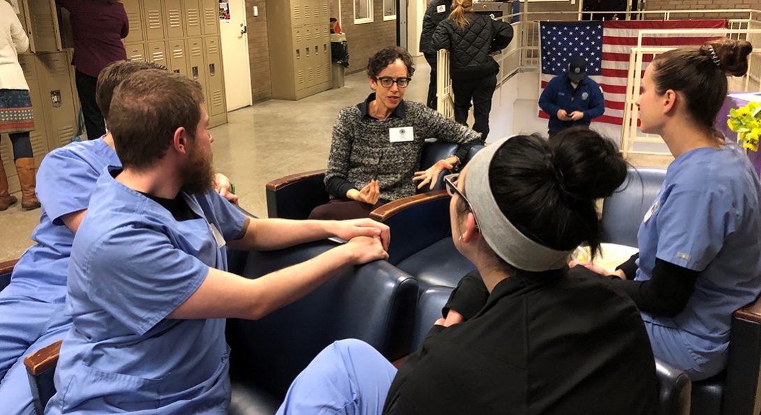 Rebecca Singer, UIC Nursing clinical assistant professor, debriefs with a group of graduate-entry master's degree students in the lobby of the juvenile detention center after an educational session there.