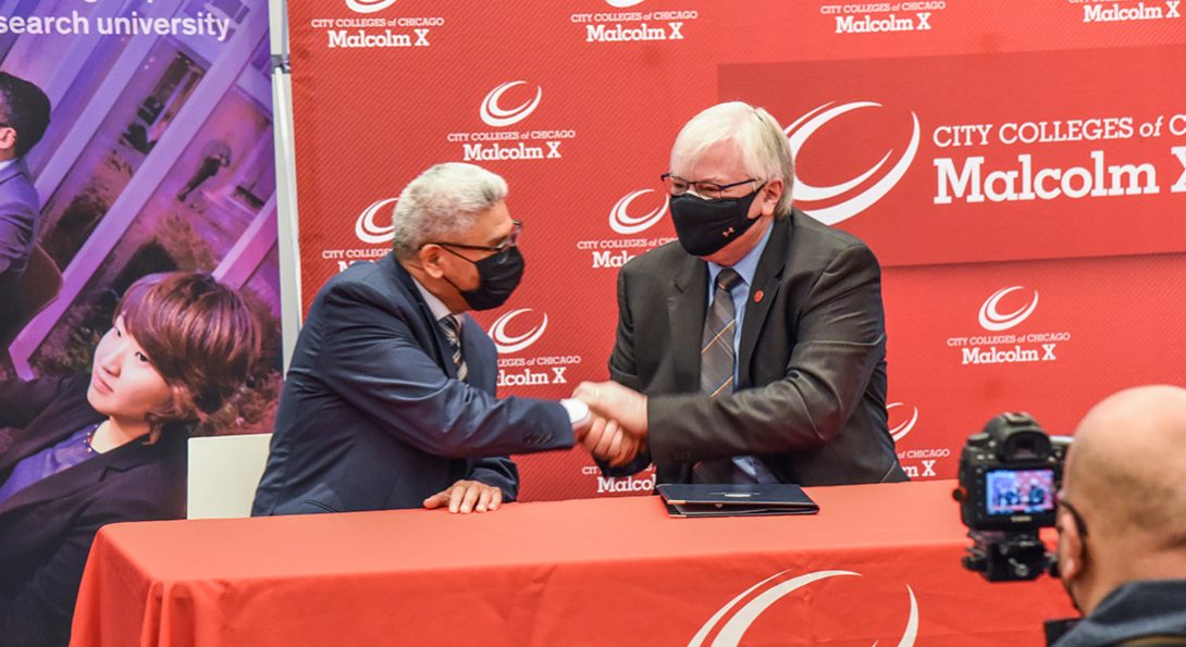 City Colleges of Chicago Chancellor Juan Salgado (left) and UIC Chancellor Michael Amiridis shake hands