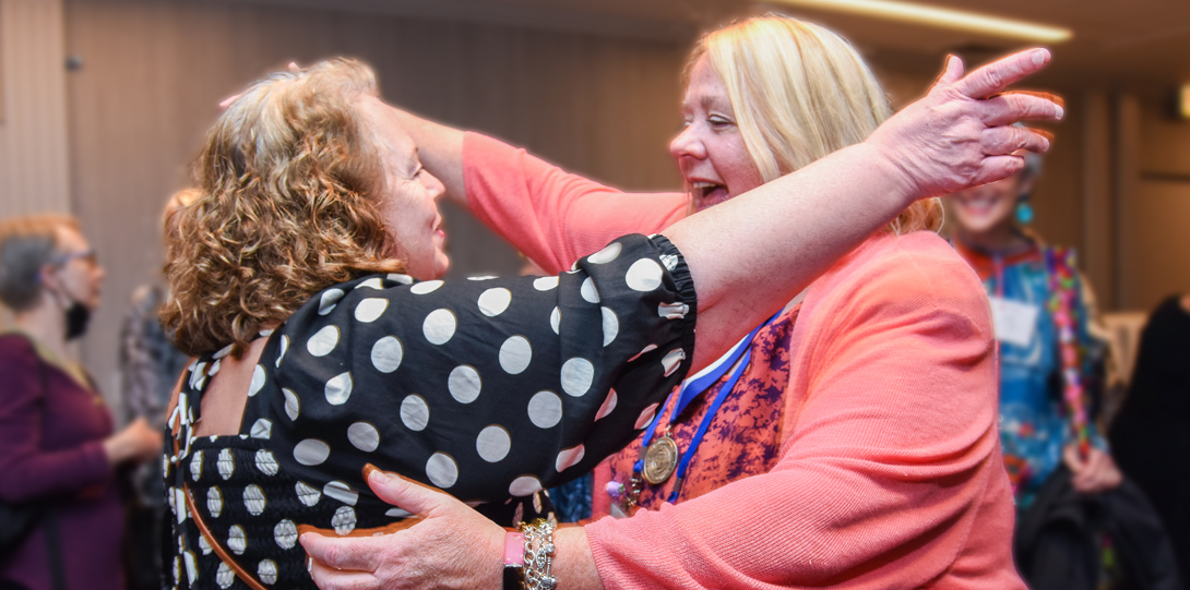 Carol Carr, MS '86, and Carrie Klima, MS ’86, current director of the UIC nurse-midwifery program, on the brink of an excited embrace