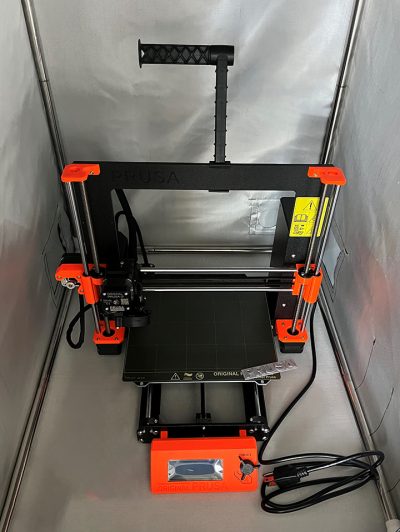 The Josef Prusa printer, housed in a fireproof, dustprooof, temperature-stable enclosure to maintain optimal performance