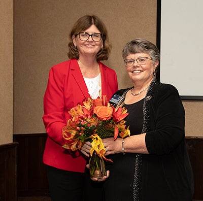 Eileen Collins and Kathleen Sparbel pose with flowers