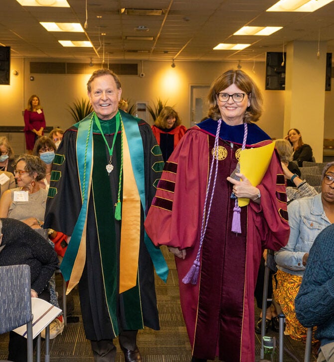 Robert Barish and Dean Eileen Collins walk down hallway