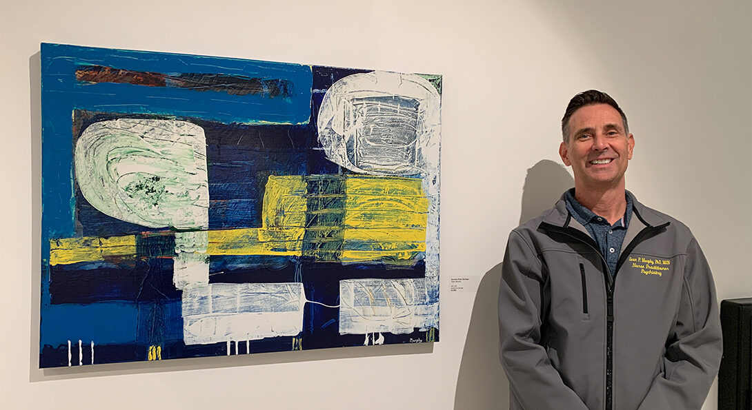 Man stands in front of painting