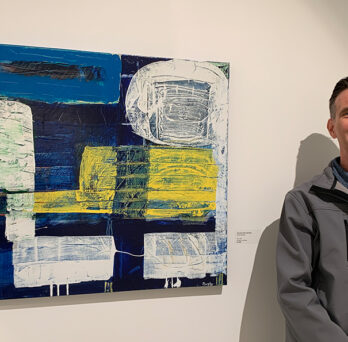 Man stands in front of painting
                  