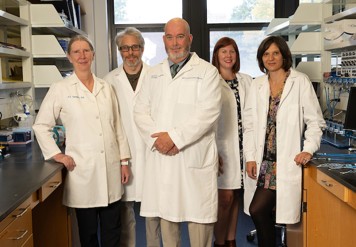 Five researchers pose in lab coats, in their lab: Ardith Doorenbos, Stefan Green, Mark Lockwood, Lisa Tussing-Humphreys and Beatrix Peñalver Bernabé