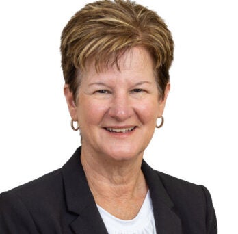 woman wearing black blazer smiles at camera 