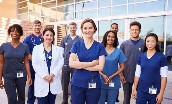 A group of various medical professionals smile for a photograph