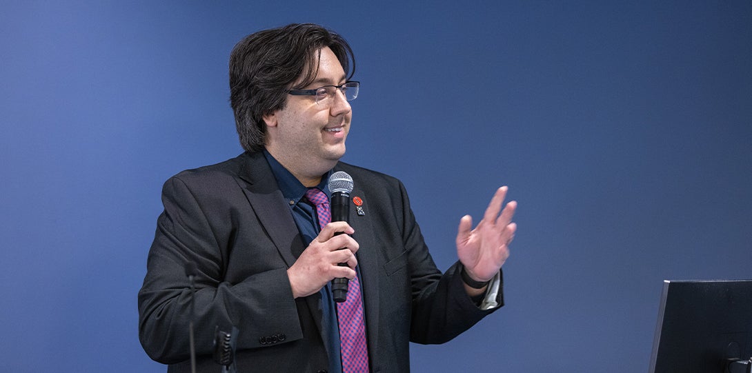 A man delivers a speech while holding a microphone