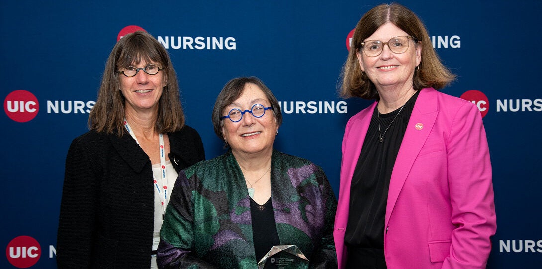 Three pose for picture with award