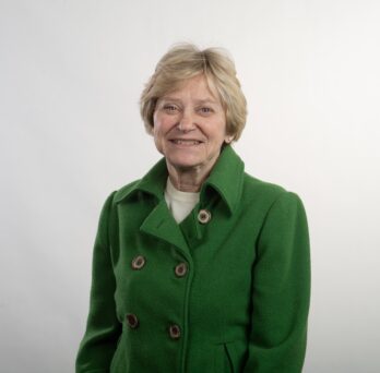 Woman in green coat smiles at camera 