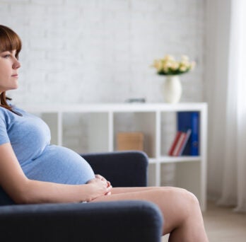 pregnant woman sits on couch
                  